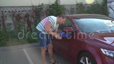 年轻的白种人正在洗车自助服务。 洗车。